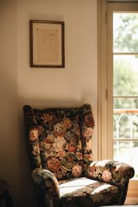 a floral couch in a room with a window at Le dimore de Il borgo del balsamico in Albinea