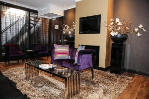 a living room with a purple couch and a coffee table at Hotel & Spa Savarin - Rijswijk, The Hague in Rijswijk