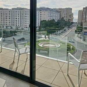 two chairs sitting on a balcony with a view of a city at LHOME CÁDIZ in Cádiz