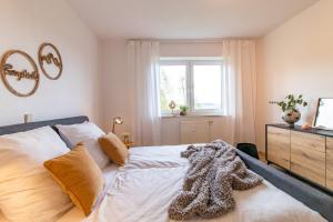Schlafzimmer mit einem Bett mit weißer Bettwäsche und einem Fenster in der Unterkunft Panorama-Apartment 2 I Balkon I WLAN I Stellplatz in Schwarzenberg