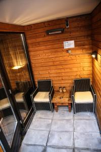 a room with two chairs and a wooden wall at Hotel & Spa Savarin - Rijswijk, The Hague in Rijswijk