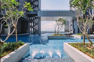 a swimming pool in the middle of a building with trees at Trevor bathtub Imperio residence seaview jonker5min in Melaka