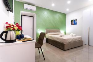 1 dormitorio con 1 cama y escritorio con mesa en Napul'è B&B, en Boscotrecase