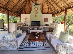 a living room with couches and a table at The Dreamcatcher Lodge in Hoedspruit