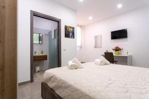 Habitación blanca con cama grande y escritorio. en Napul'è B&B, en Boscotrecase