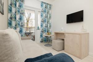 a living room with a couch and a tv at Apartament ANTEK Dziwnówek nad morzem in Dziwnówek