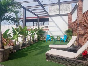 un patio con césped artificial, sillas y plantas en Habitación Recién restaurada - POD A, en Cartagena de Indias