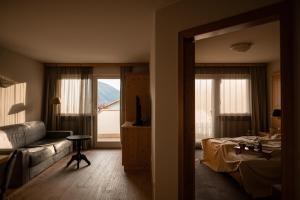 un soggiorno con divano, letto e finestra di Landpalais Goyenhof - Deluxe Suites & Breakfast a Scena