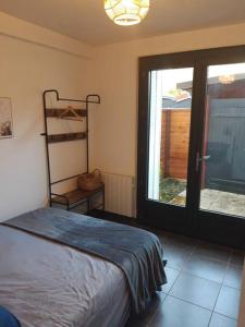 een slaapkamer met een bed en een glazen schuifdeur bij T2 Rungis Mermoz Lenôtre Orly in Rungis