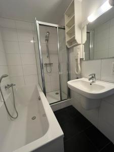 een witte badkamer met een wastafel en een douche bij Appartementen het Centrum in Domburg