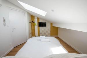 Habitación blanca con cama y TV en WelcomeAgen*Gatsby*Clim*Fibre en Agen