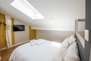 1 dormitorio con 1 cama blanca y TV en WelcomeAgen*Gatsby*Clim*Fibre en Agen