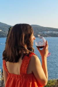 Eine Frau in einem roten Kleid, die ein Glas Wein trinkt. in der Unterkunft Apartment Ana Lozica with terrace in Dubrovnik