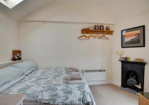 a bedroom with a bed and a fireplace at The Den in Lynmouth