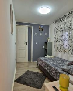 Schlafzimmer mit einem Bett, einem Fenster und einer Tür in der Unterkunft Apartment Ana Lozica with terrace in Dubrovnik