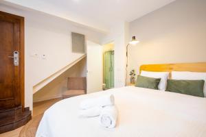 sypialnia z dużym białym łóżkiem z ręcznikami w obiekcie Hotel Donosti w mieście San Sebastián +37 zdjęć