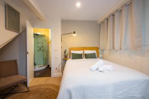 sypialnia z dużym białym łóżkiem z ręcznikami w obiekcie Hotel Donosti w mieście San Sebastián