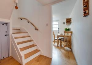 a white staircase in a living room with a table at Dolphin Cottage in Braunton
