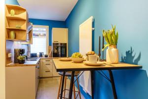 a kitchen with blue walls and a wooden counter top at Kleine Quelle Wernigerode in Wernigerode
