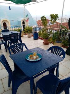 ein blauer Tisch und Stühle mit einem Teller Essen drauf in der Unterkunft KOTSIFAS ROOMS in Tiros