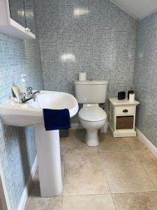 a bathroom with a white sink and a toilet at Ardean House in Moy
