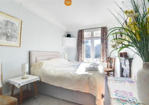 um quarto com uma cama e um vaso com uma planta em The Edwardian House em Ilfracombe