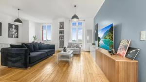 sala de estar con sofá azul y TV en HOMEY AWESOME - Proche Gare et Tram - Centre-ville - Balcon privé - Wifi gratuit, en Annemasse