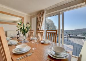 a dining room table with a view of a balcony at The Farthings in Ilfracombe