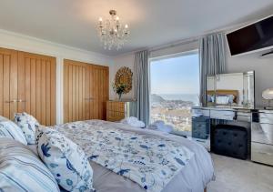 a bedroom with a large bed and a large window at The Farthings in Ilfracombe