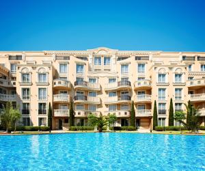 a large swimming pool in front of a building at Bellicity Apart Complex in Ravda