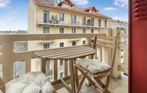 a wooden table and chairs on a balcony with a building at HOMEY AWESOME - Proche Gare et Tram - Centre-ville - Balcon privé - Wifi gratuit in Annemasse