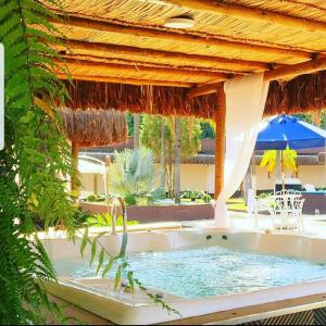 a hot tub in a resort with an umbrella at Sumaré Park Hotel in Sumaré