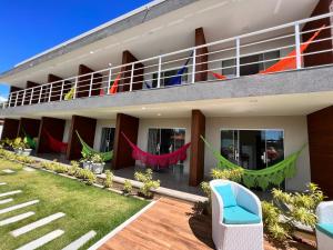 a building with a balcony with hammocks on it at VilaMar Jacuípe in Camaçari