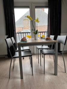 a dining room table with chairs and a window at Appartementen het Centrum in Domburg