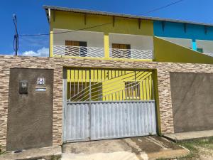 a house with a white and yellow garage door at Linda Casa com piscina Brisa do Mar - Maragogi in Maragogi
