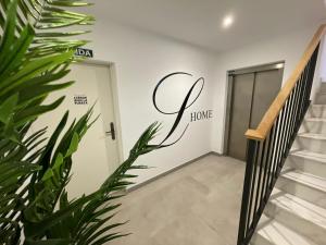 a hallway with a door with a home sign on the wall at LHOME CÁDIZ in Cádiz