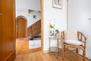 un couloir avec une chaise, une table et un escalier dans l'établissement Hotel Donosti, à Saint-Sébastien