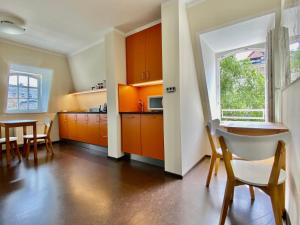eine Küche mit orangefarbenen Schränken sowie einem Tisch und Stühlen in der Unterkunft Hofgärtnerhaus in Dresden