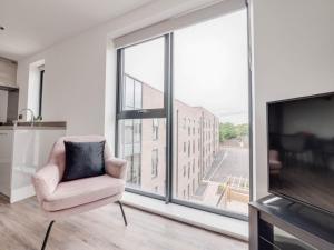 a living room with a chair and a large window at Modern 2 Bedroom Apartment Manchester Media City in Manchester