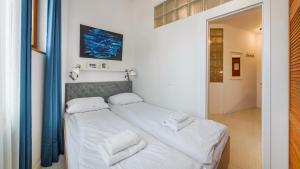 sypialnia z 2 łóżkami z białą pościelą i ręcznikami w obiekcie Apartamenty Sun & Snow Traugutta Plaża w mieście Sopot