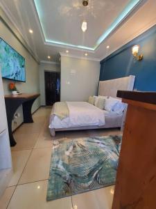 a hotel room with a bed and a tv at Cozy Studio Stay Kilimani Valley Acarde Area in Nairobi