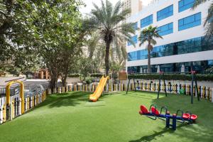 un parque infantil con tobogán y toboganes en el césped en Sheraton Jumeirah Beach Resort en Dubái