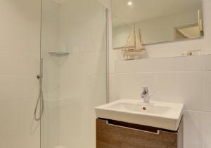 a white bathroom with a sink and a shower at Fox Cottage in Lynmouth