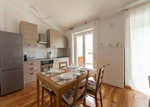 una cucina con tavolo, sedie e frigorifero di Alloggio Turistico Flavia ad Anzio