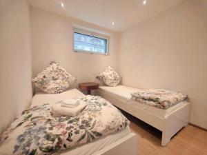 a small bedroom with two beds and a window at FeWo Interlaken in Interlaken