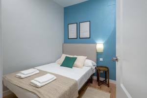 a bedroom with a bed with a blue wall at 2 bedrooms 2 bathrooms furnished - Las Letras - Modern - MintyStay in Madrid