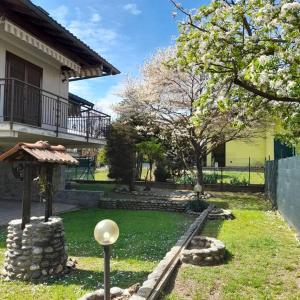 um jardim em frente a uma casa com uma árvore em Il Vecchio Kiwi - House with private garden em Oleggio Castello