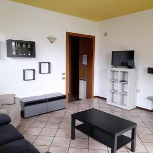 uma sala de estar com um sofá e uma mesa de centro em Il Vecchio Kiwi - House with private garden em Oleggio Castello