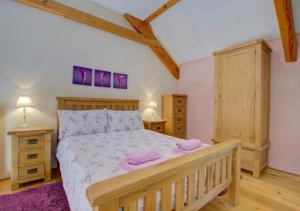a bedroom with a wooden bed and two night stands at The Gearing in Bampton