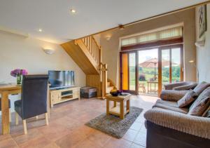 a living room with a couch and a television at The Gearing in Bampton